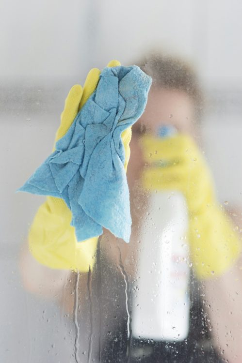 Woman cleaning glass pane